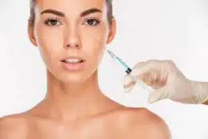 close up of a beautiful young woman gets beauty injection in eye area with syringe iso SBI 302779281 1920w