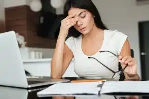 photo of young tired woman analyzing home finances with laptop while suffering eyestra SBI 302895393 1920w