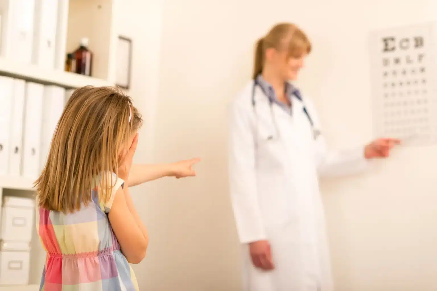ophthalmologist visit child reading eye chart at pediatrician office SBI 300904361 1920w ophthalmologist visit child reading eye chart at pediatrician office SBI 300904361 1920w
