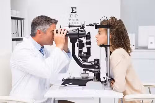 General Eye Care Exam Milwaukee Eye Surgeons, Brookfield, WI Woman doing eye test with optometrist in medical office